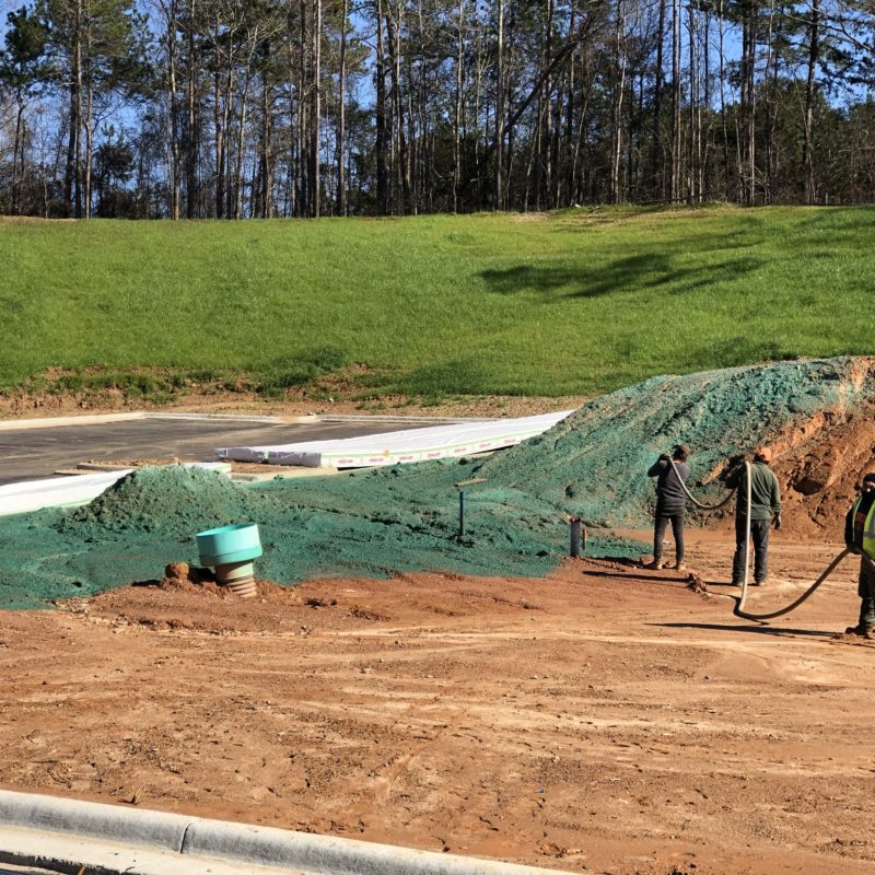 men hydroseeding an area of soil in huntsville, alabama